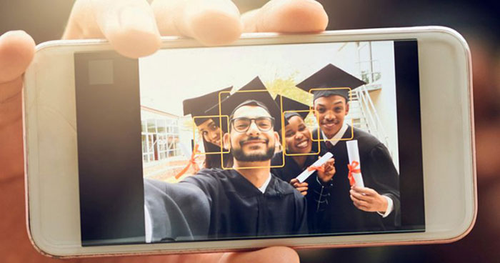 نمایش یک عکس سلفی از فارغ التحصیلان در صفحه ی یک گوشی در دست