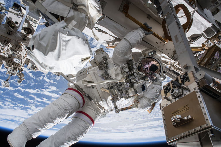 فضانوردی که در حال کار با یک ماشین فضایی در یکی ایستگاه فضایی است 